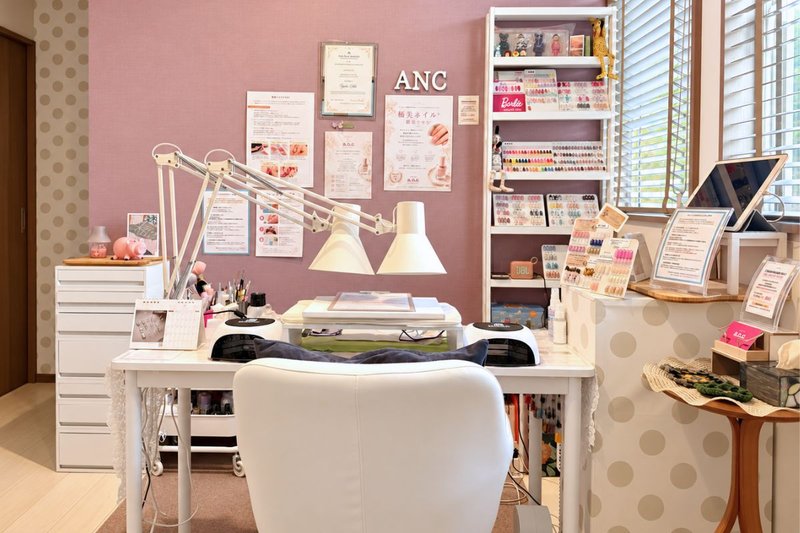 nail salon a.n.cのピンクの壁に白い家具を合わせた完全個室の施術スペース